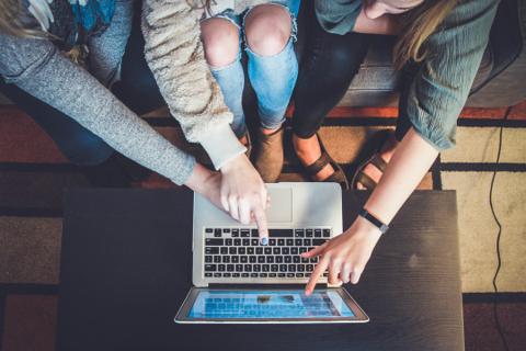 Equipo colaborando alrededor de una computadora